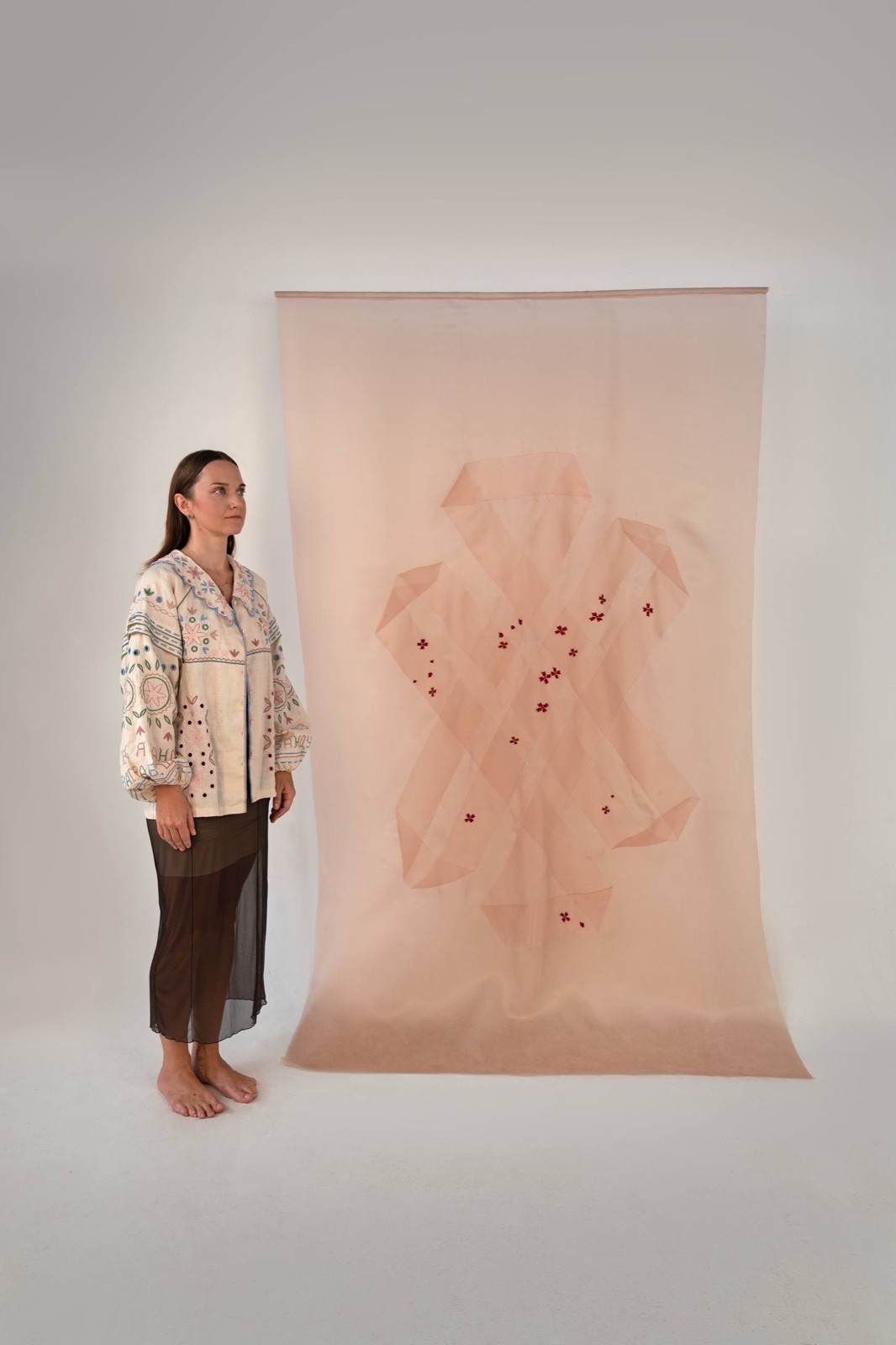 Kate Kulish standing beside The Tibetan Knot in Ukrainian Thread